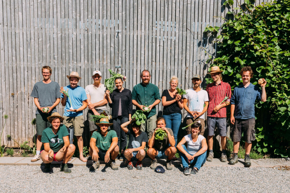 Gruppenfoto vor Holzwand mit Pflanze Gemüsemenschen