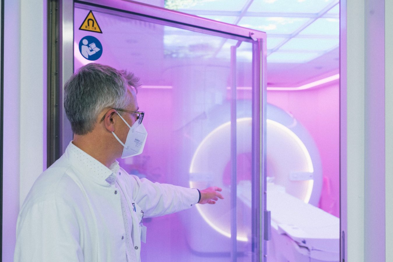 Arzt vor Glastür mit MRT Gerät im Hintergrund Canon Medical