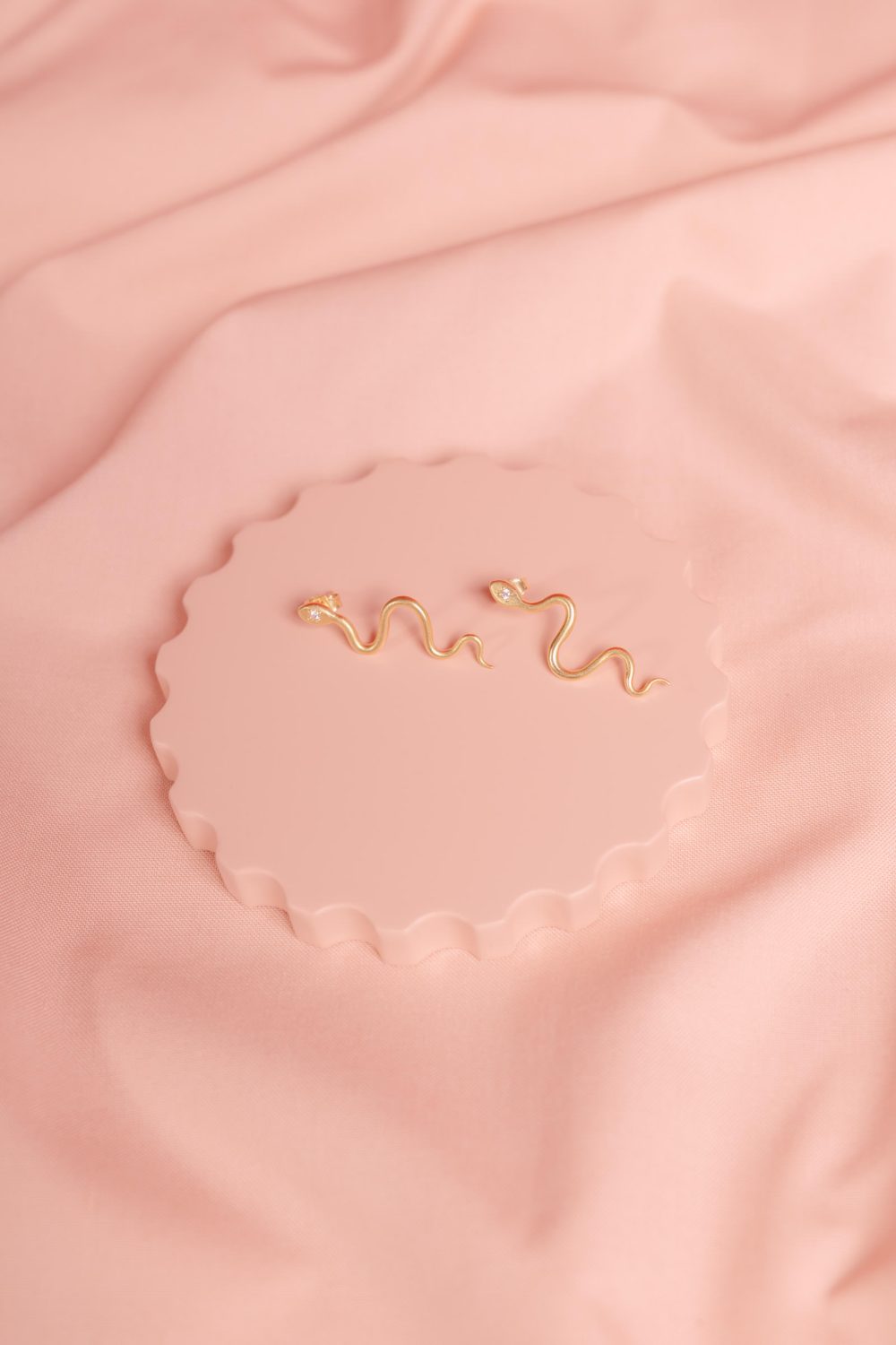 Produktfotografie Schmuck Ohrring auf rosanem Hintergrund